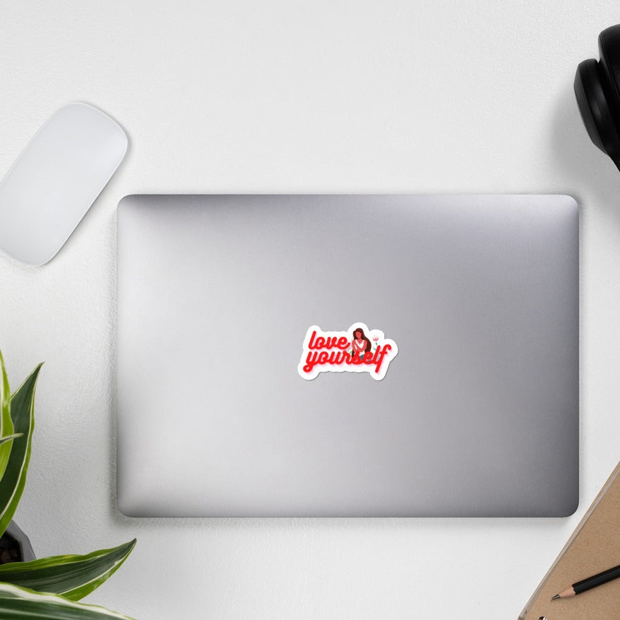 a 3 x 3 sticker that says love yourself with a lady hugging herself being displayed on a laptop computer